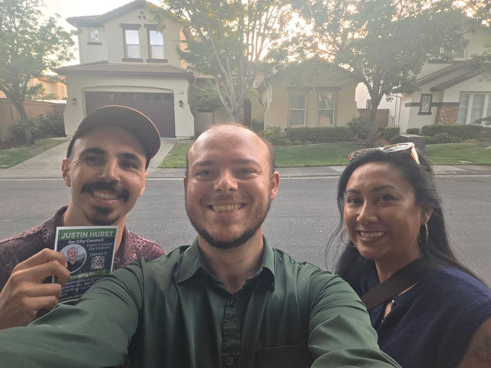 Justin taking a selfie with two volunteers on a neighborhood street