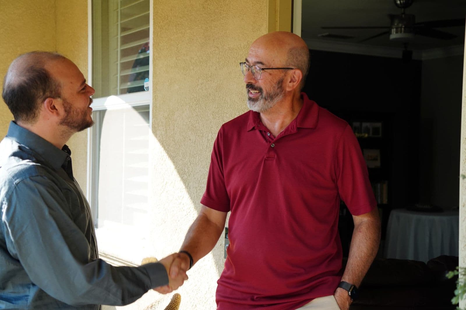Justin shaking hands with a resident at his front door