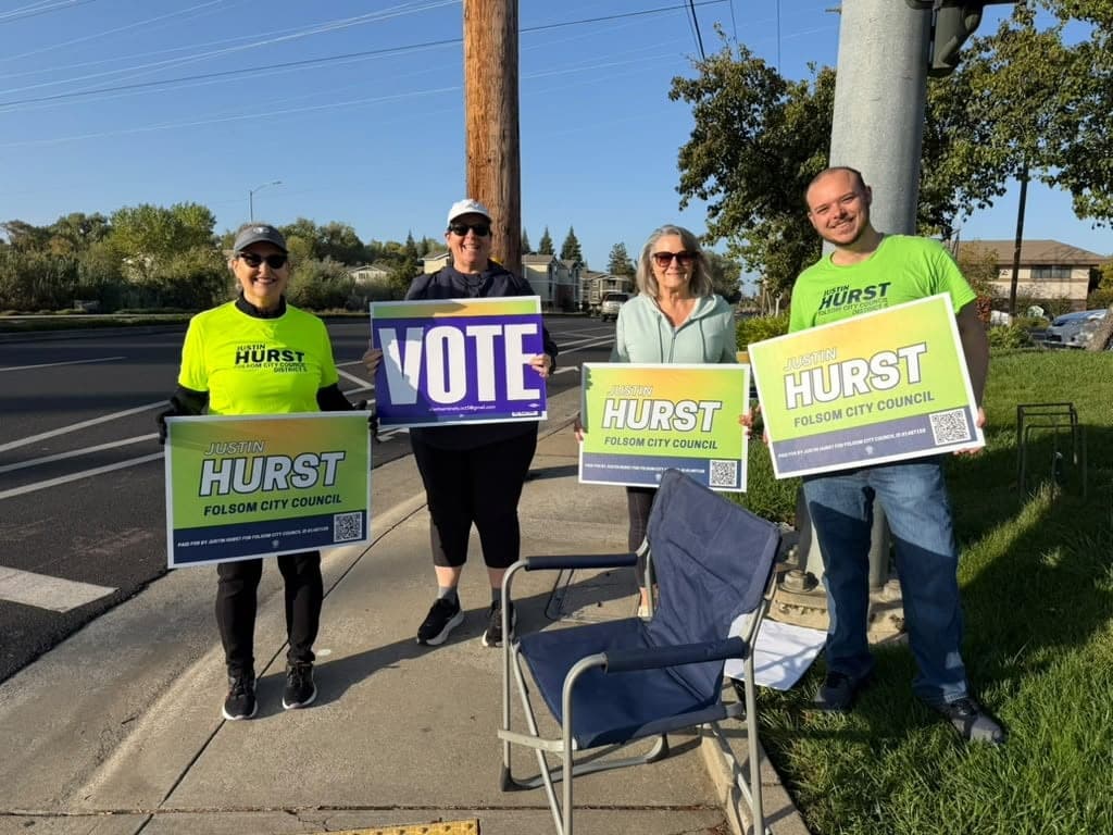 Justin and three volunteers holding Hurst and Vote signs at a street corner